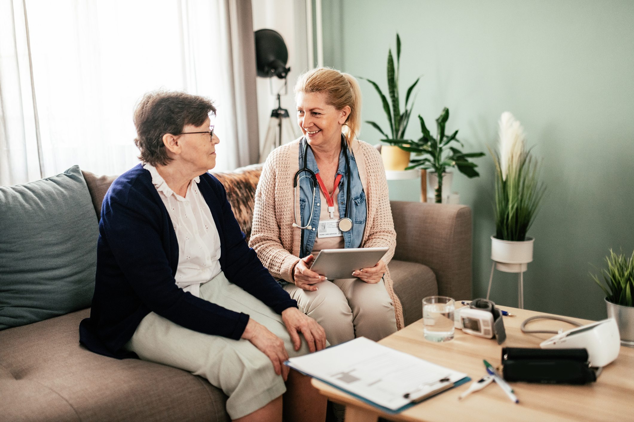 Elderly woman sitting with health professional.