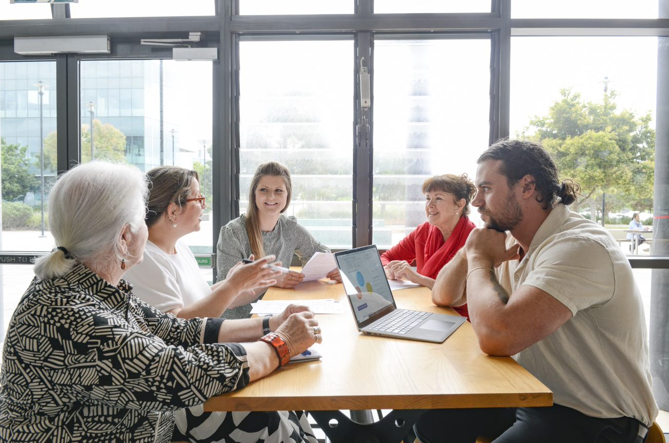 Group of consumers sitting at table and chatting.