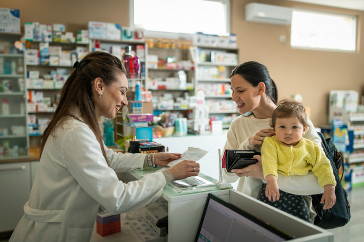 Woman and baby speaking with pharmacist.