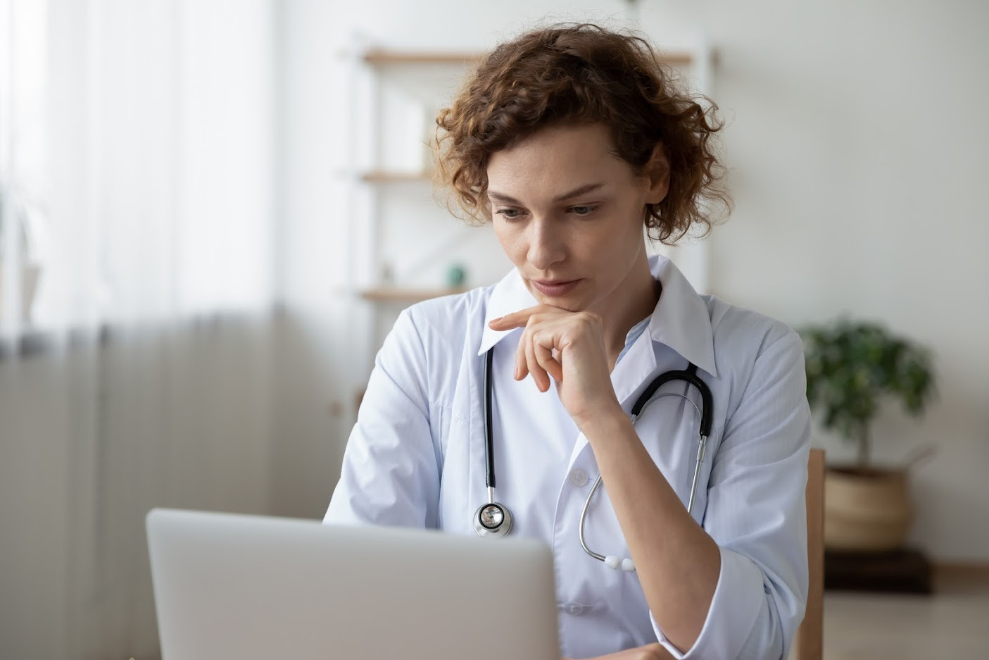 Female doctor looking at laptop.