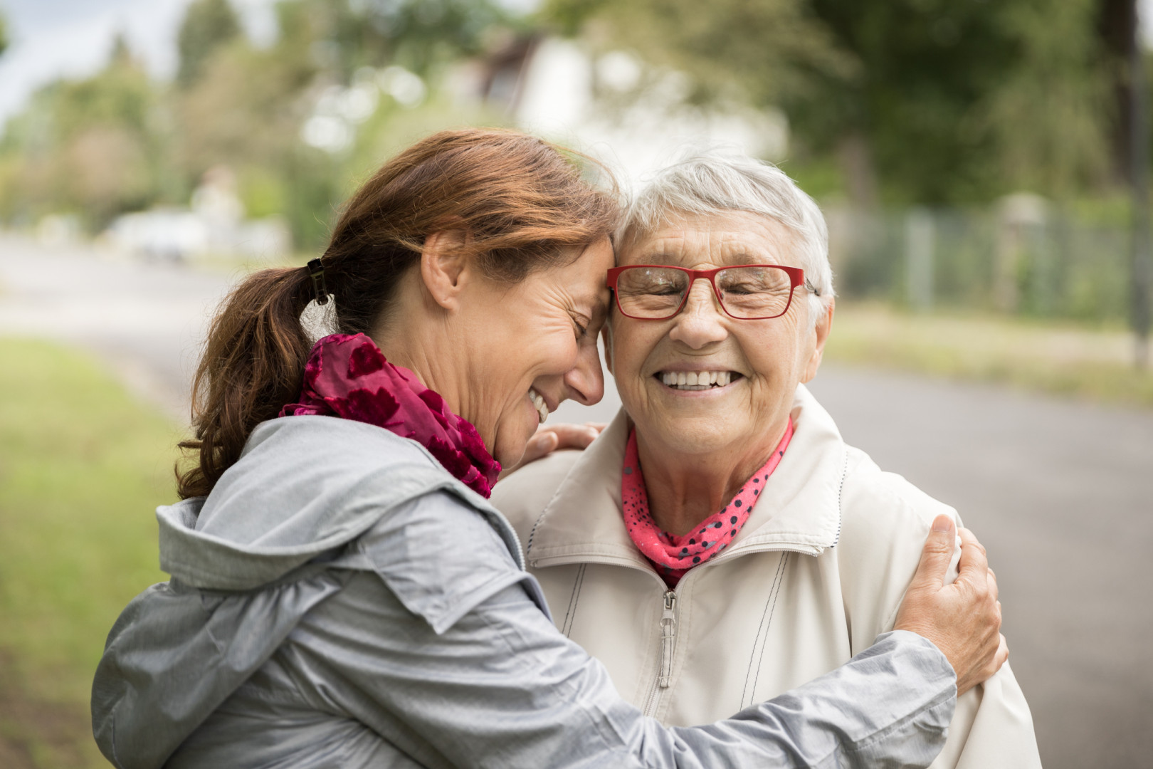 Daughter hugging elderly mother.