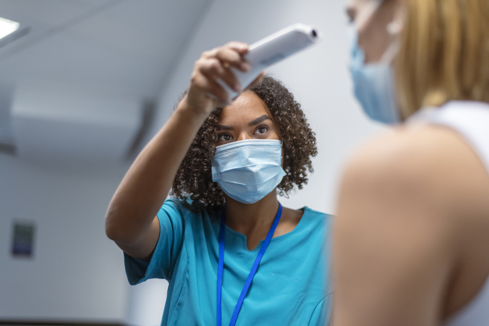 Nurse checking temperature of patient.