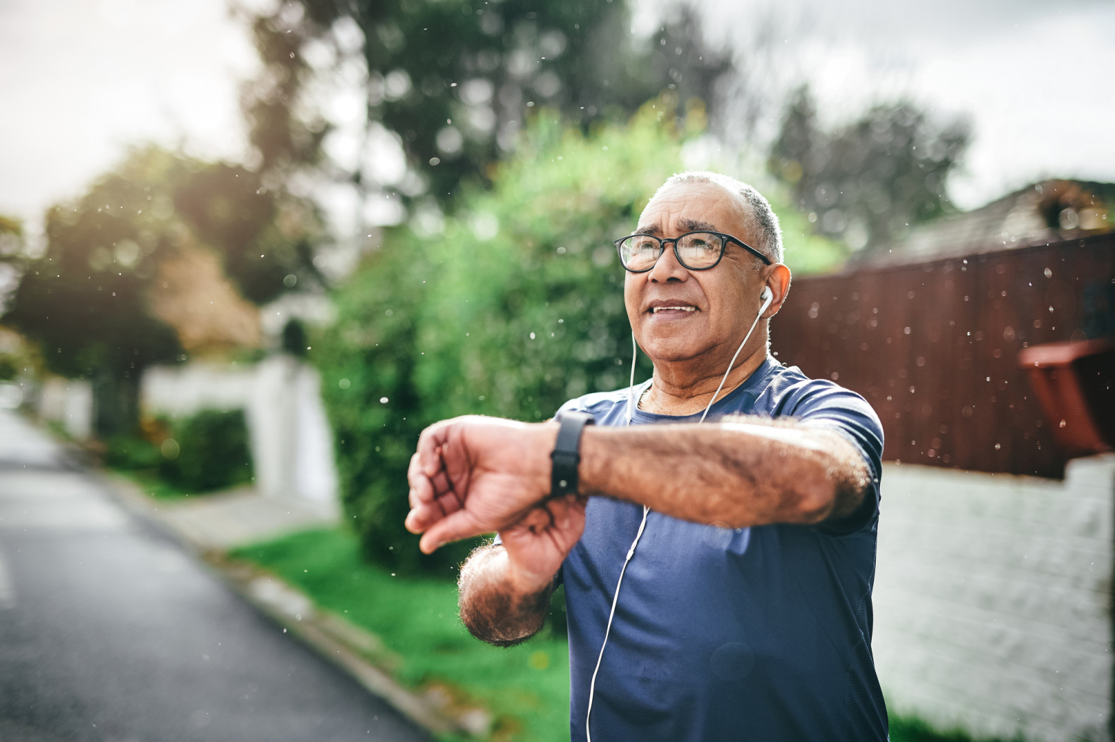 Older man checking his smart watch whilst out on a walk
