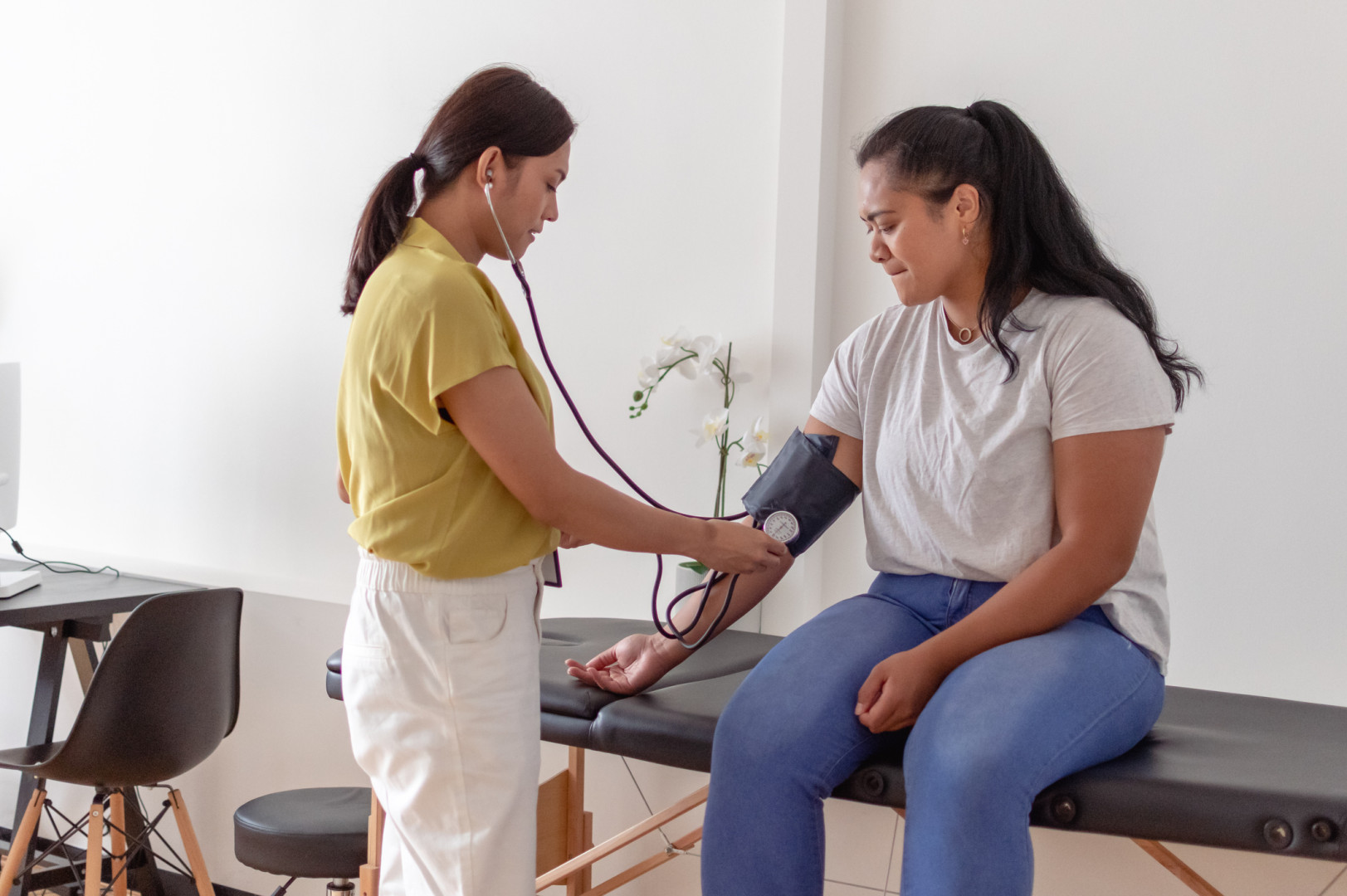 Female GP speaking with a patient at their desk