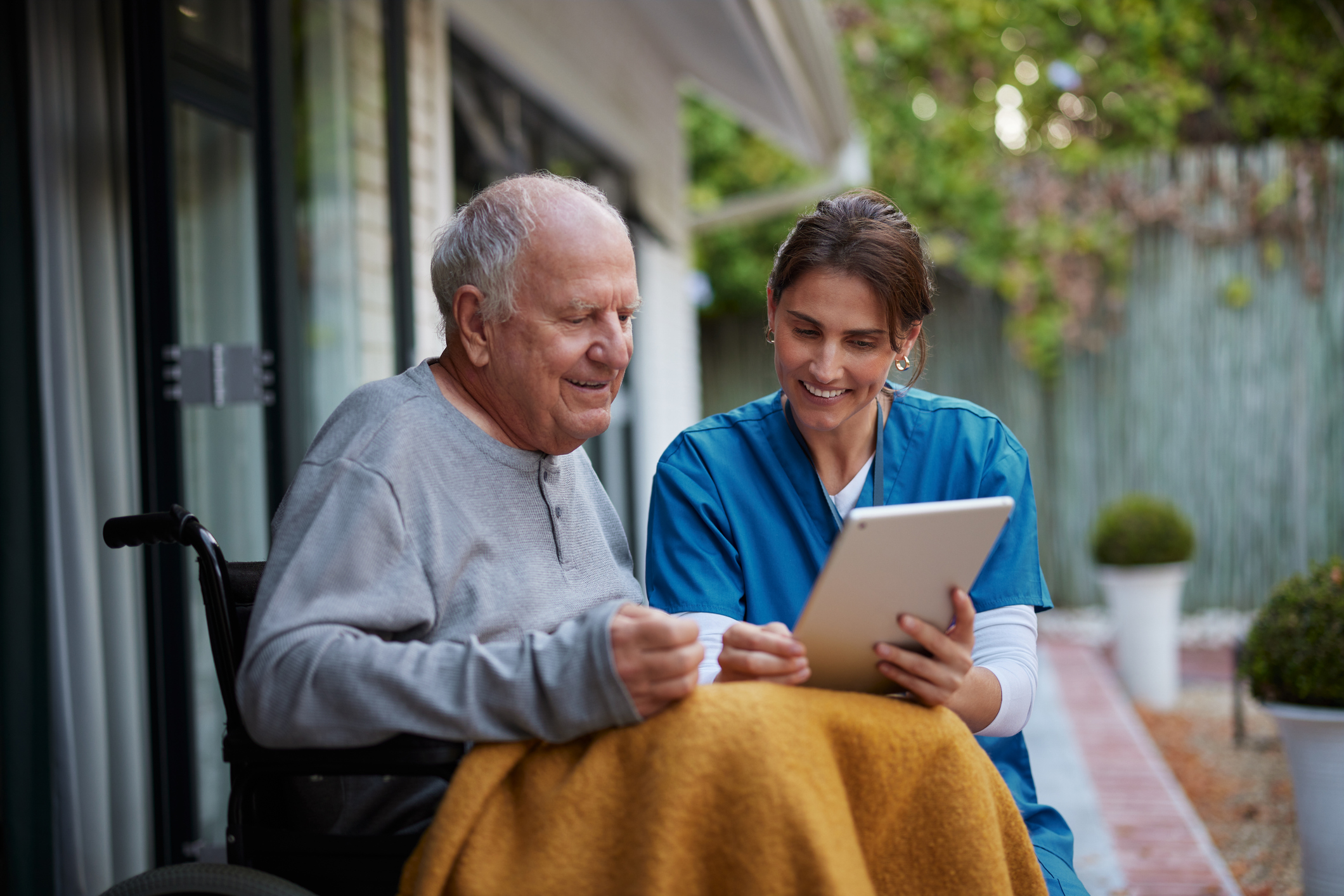 Elderly man sitting with a pharmacist outside