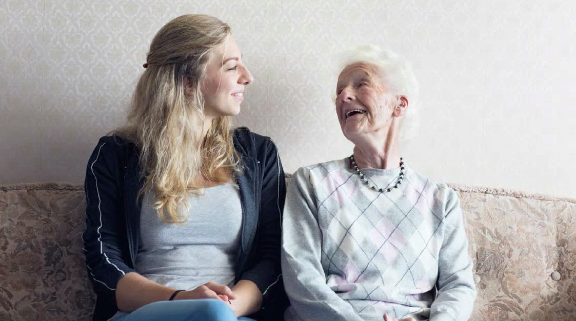 Two ladies smiling at each other.