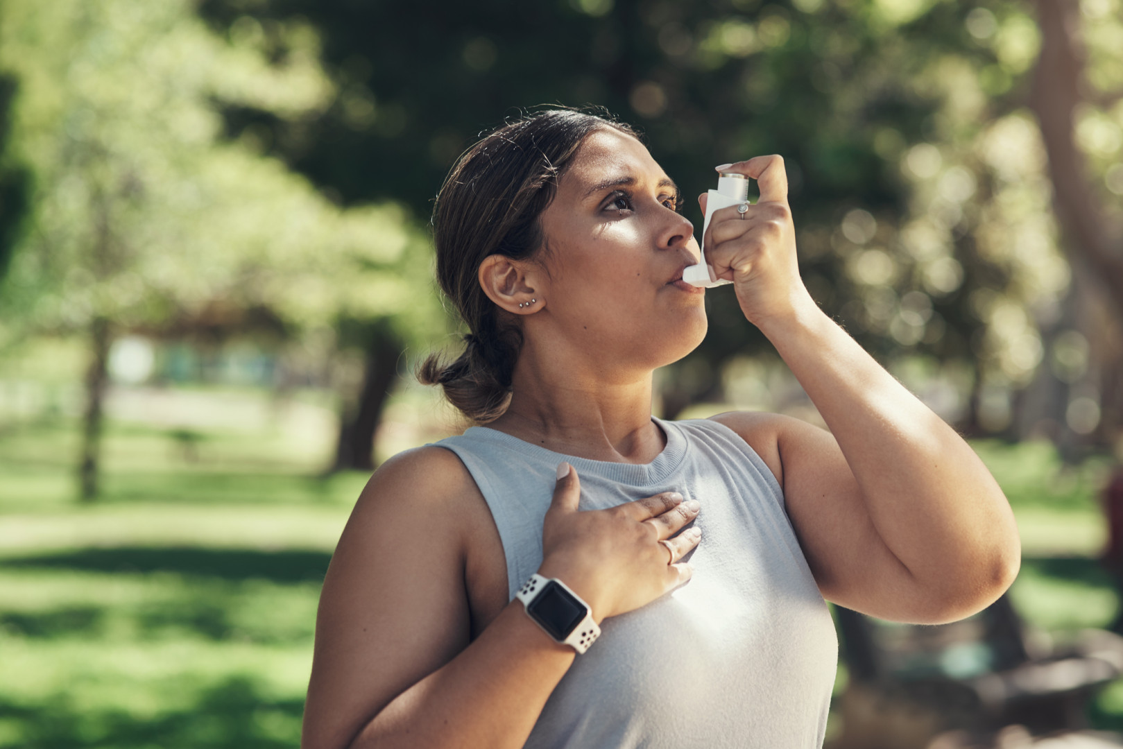 Young woman using an inhaler.