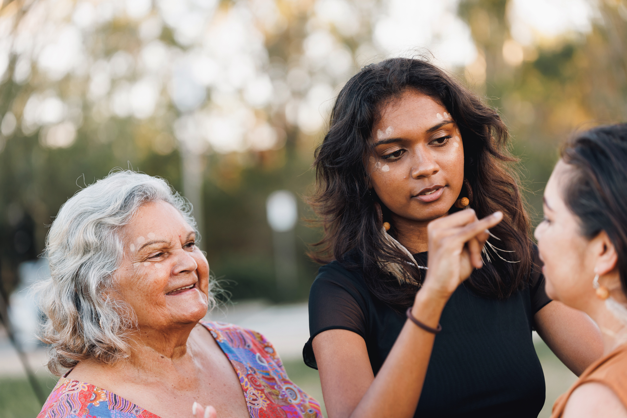 Aboriginal women smiling at each other outside