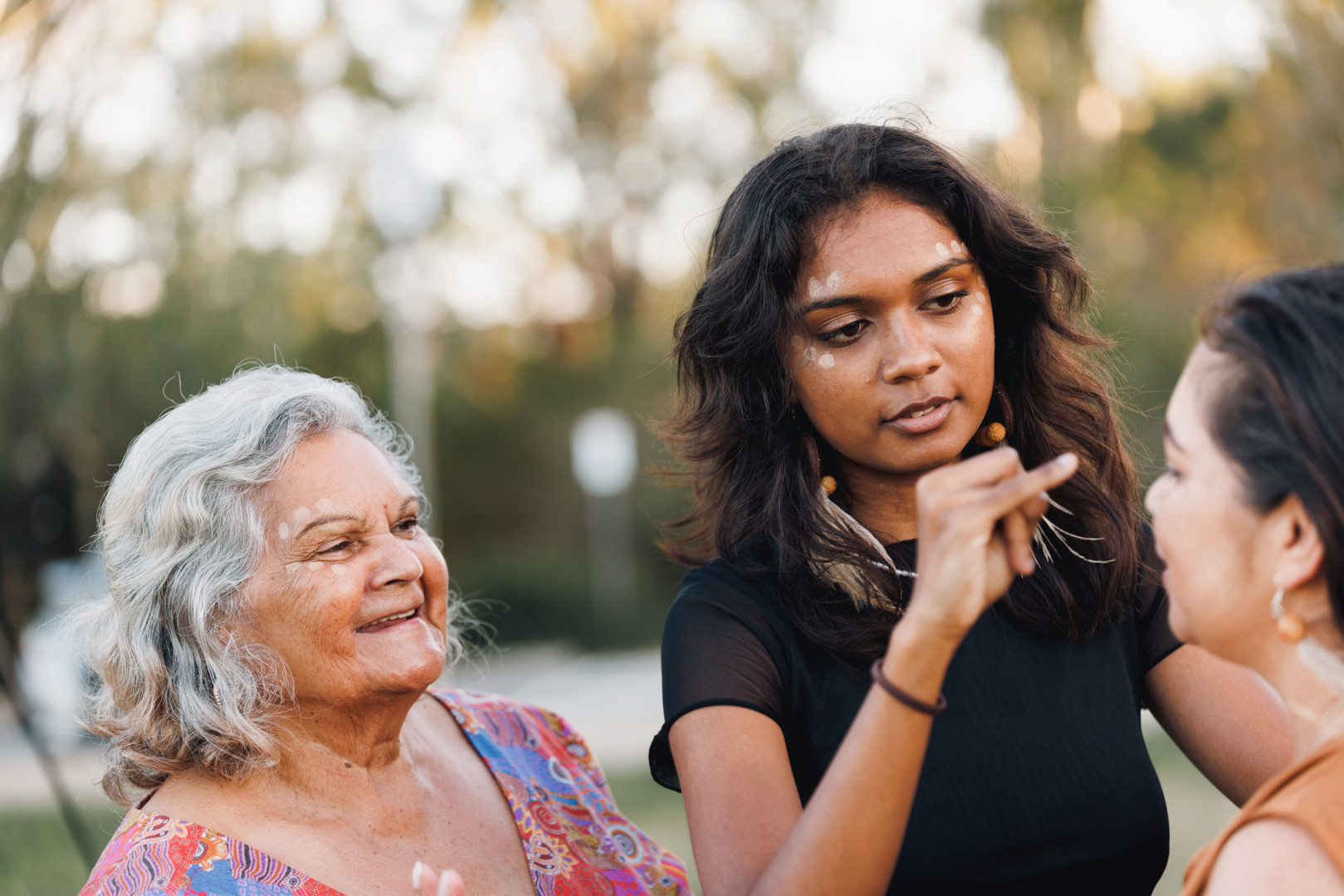 Aboriginal women smiling at each other outside