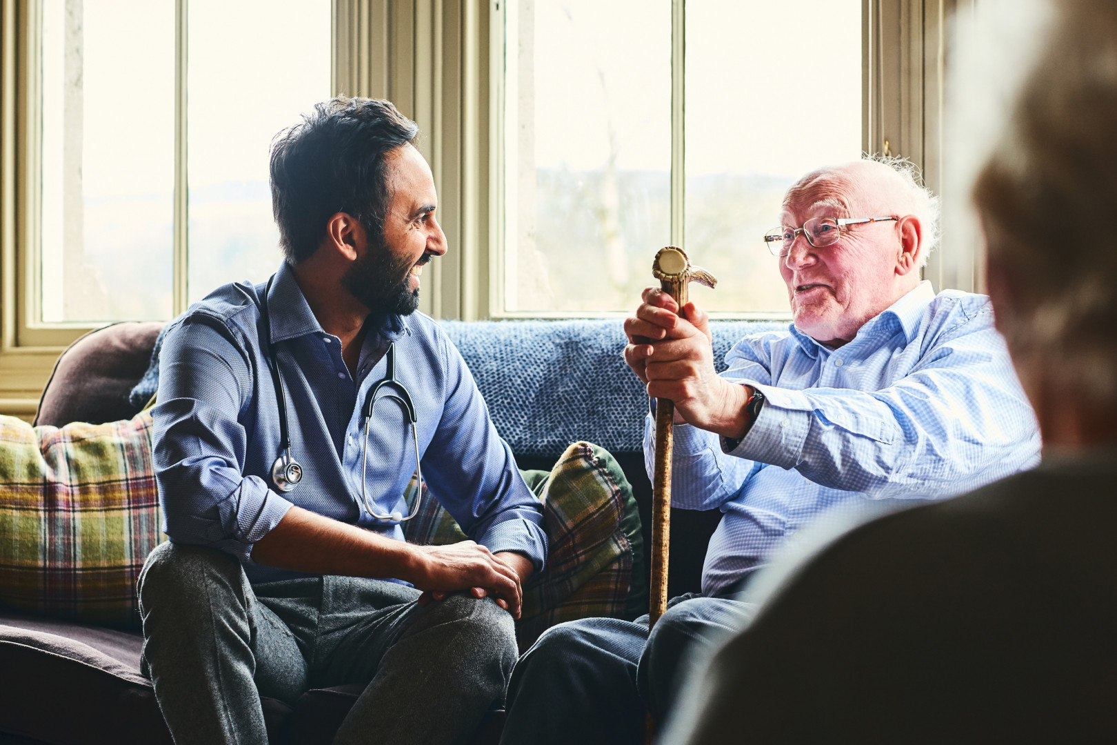 General Practitioner speaking with an elderly person on a couch