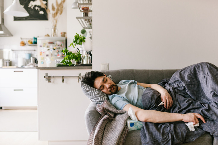 Man laying on lounge, unwell.