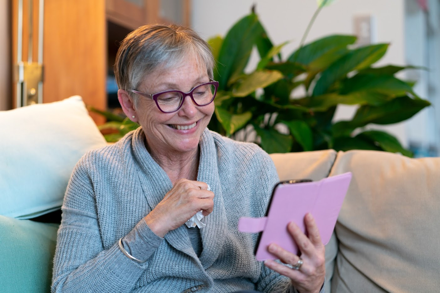 Woman using phone and smiling.