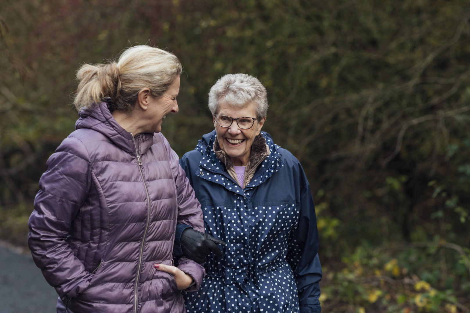 Daughter walking with elderly mother.