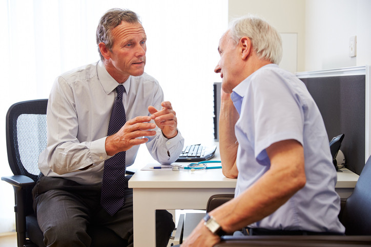 Male GP, speaking with patient.