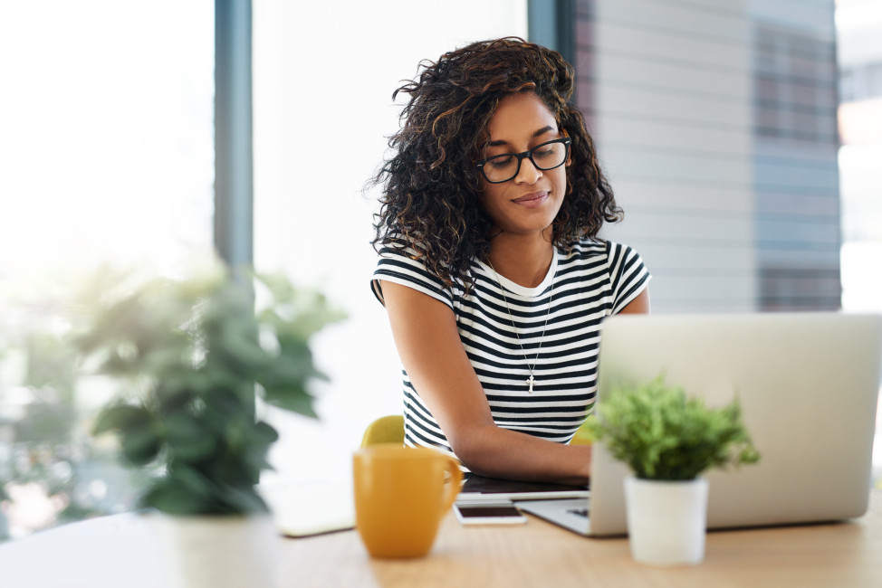 Woman with coffee and on laptop, participating in online discussion.